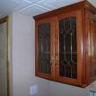 Wall cabinets with diamond pattern glass doors.